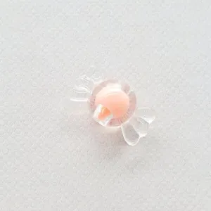 Primer plano de cuenta acrilica transparente en forma de caramelo con nucleo rosa diy.