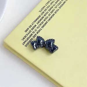 Close-up of a dark glossy acrylic bow DIY accessory featuring a cute dotted lace edge design.