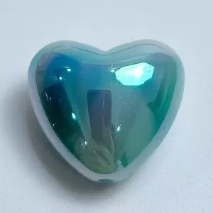 Close-up detail of iridescent gradient heart-shaped bead, perfect for DIY jewelry crafting.