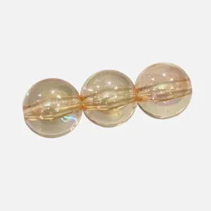 Acrylic bead material detail view showcasing three glossy champagne spheres with AB color.