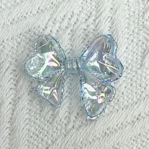 Transparent iridescent bow acrylic DIY jewelry accessory close up showing colorful light details.