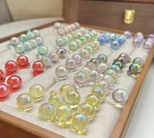 Detailed close-up of colorful iridescent acrylic UV-plated bubble charm beads with hanging loops.