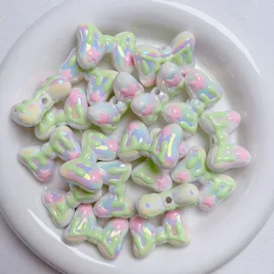 Close-up of iridescent pastel bow acrylic beads, perfect for DIY jewelry and phone charms.