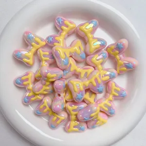 Detailed close-up of macaron acrylic bow beads with cute drip designs for DIY jewelry making.