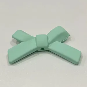 Fiocco in silicone dettaglio, accessorio fai da te verde chiaro per cover e mollette per capelli.