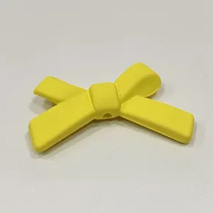 Primo piano accessorio fiocco giallo DIY, ciondolo nastro carino per cover e molletta.