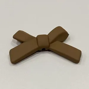Primo piano di un fiocco marrone in silicone, texture opaca, ideale per decorare cover.