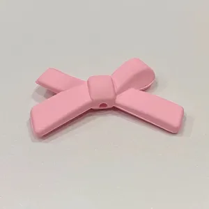 Ciondolo fiocco in silicone rosa, accessorio fai da te grazioso per cover telefono e dettagli.