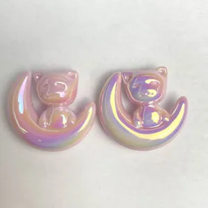 Primo piano dettagliato di ciondoli per gioielli fai da te gatto luna in acrilico rosa olografico.