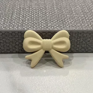 Primo piano di un grazioso fiocco bianco crema accessorio fai-da-te per custodie e mollette.