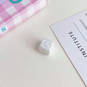 Perlina quadrata lettera acrilico bianco accessorio gioiello DIY primo piano dettaglio