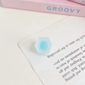 Detailaufnahme einer blauen, mattierten sechseckigen Acrylperle mit zweifarbigem Design.