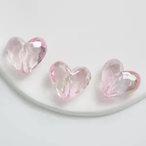 Vista dettagliata di perline a cuore sfaccettate iridescenti rosa trasparente, accessorio.