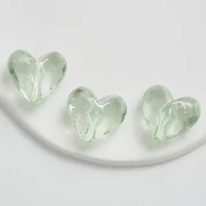 Dettaglio perle cuore in acrilico verde chiaro, perfette per catene telefono e gioielli.