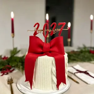 Close up detail of 2027 new year cake topper acrylic red bow knitted cake party decor setting
