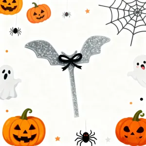 Detail view of the silver glitter bat cake topper with a black bow for Halloween party decor.