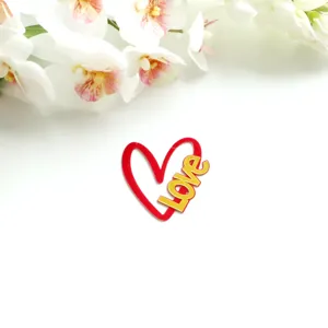 Nahaufnahme eines roten Acryl-Herz-Kuchendeppers mit goldener Aufschrift zum Valentinstag.