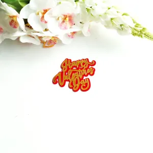 Detail shot of red and gold acrylic Happy Valentines Day cake topper with floral decor.