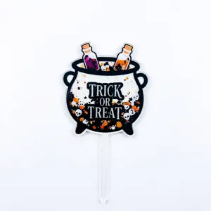 Halloween acrylic cake topper detail showing black cauldron design for party decor.