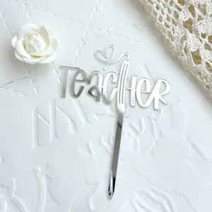 Detailansicht des silbernen Acryl Kuchenaufsatzes fur Lehrer mit Stift- und Herz-Motiv.