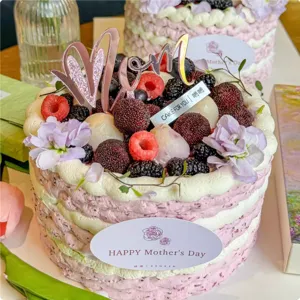 Primo piano di una torta artigianale per la festa della mamma con bacche e fiori freschi.