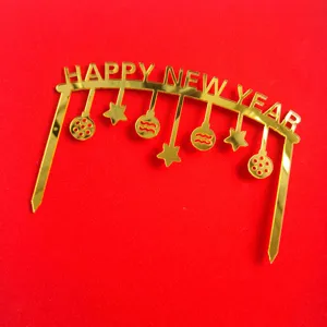 Gold acrylic Happy New Year cake topper, arched design with hanging ornaments, detail view.