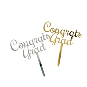 Acrylic graduation cake topper detail showing metallic gold and silver Congrats Grad designs.