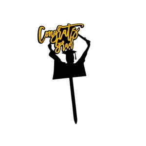 Close-up detail of black and gold acrylic graduation cake topper with Congrats Grad text.