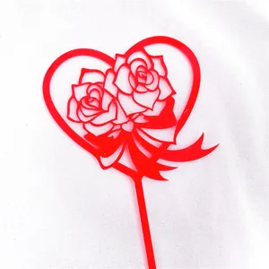 Close-up view of the red acrylic heart-shaped cake topper featuring delicate roses and bow design.