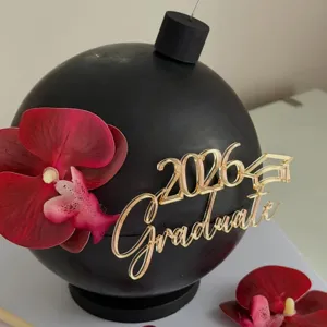 Nahaufnahme der 2026 Abschluss Torte Dekoration mit goldenen Buchstaben und roten Blumen.