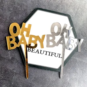 Gros plan détail de cake topper OH BABY en acrylique or et argent pour fête d'anniversaire.