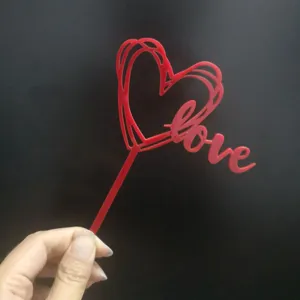 Red acrylic heart cake topper with love script, perfect for romantic Valentine's Day party decor.