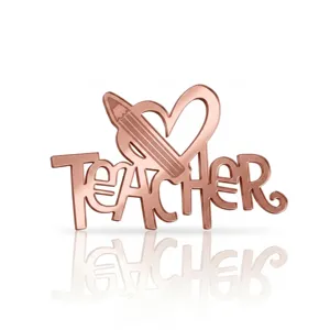 Detailed close-up of rose gold acrylic TEACHER cake topper with heart and pencil design.