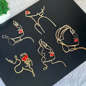 Close-up view of gold acrylic abstract face line art cake toppers set, minimalist art design.