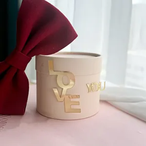 Detailed view of the pink gift box with gold acrylic love you letters and red velvet bow.