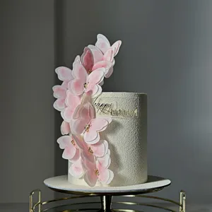 Gros plan de charmants toppers de gâteau papillon rose dégradé avec paillettes et plaque acrylique.