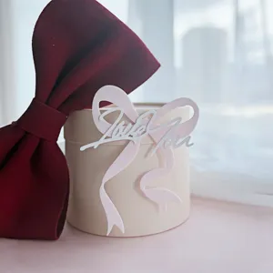 Romantic Valentine's Day acrylic cake topper with bow and Love You text for party decor.