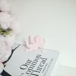 Pink cupid cake topper detail shot, charming paper angel decor for Valentine party.