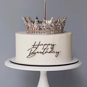Vue détaillée d'un cake topper couronne strass dorée et d'un panneau joyeux anniversaire noir.