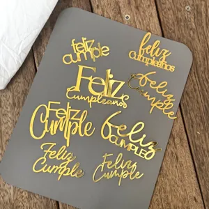 Vista dettagliata di topper per torta di compleanno in acrilico dorato con scritte in spagnolo.