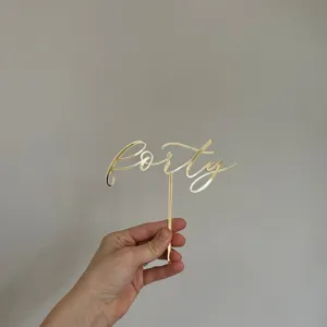Detail view of gold acrylic forty cake topper for birthday party decor close up