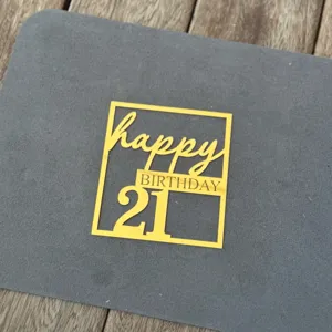 Gold acrylic 21st birthday cake topper detail, sparkling finish for party dessert table decor.