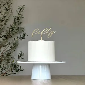 Gold acrylic fifty cake topper for birthday party cake decoration, elegant minimalist design.