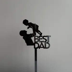 Detail view of black acrylic Best Dad cake topper for Father's Day party decor.