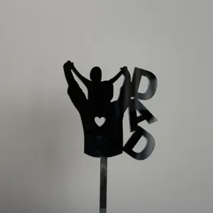 Close-up detail of the black acrylic father's day cake topper with silhouette design.