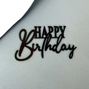 Nahaufnahme Detailansicht schwarzer Acryl Happy Birthday Kuchendekoration fuer Party.