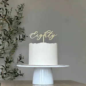 Gold acrylic Eighty cake topper detail, elegant party decoration for 80th birthday celebration.