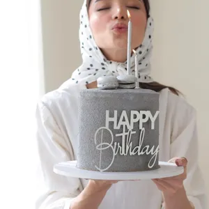 Vista dettagliata del topper per torta 'Happy Birthday' in acrilico bianco su torta grigia