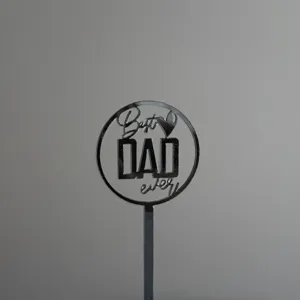 Detailed view of black acrylic cake topper with Best DAD ever text for Father's Day party.