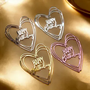 Nahaufnahme von Acryl Herz Geburtstag Tortenauflegern in Gold Silber Rosa Partydekor.